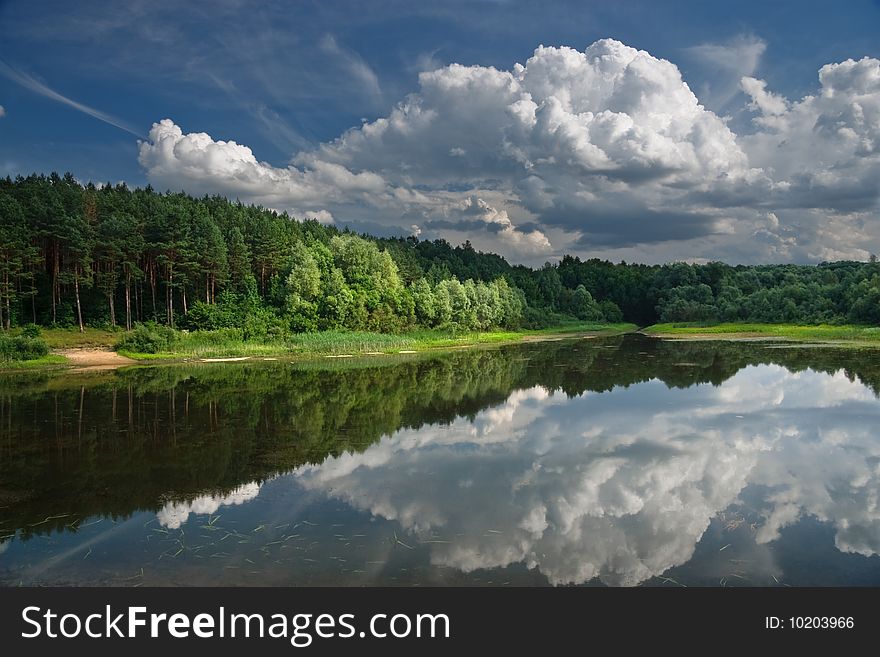 Landscape with lake on which coast a pine forest.