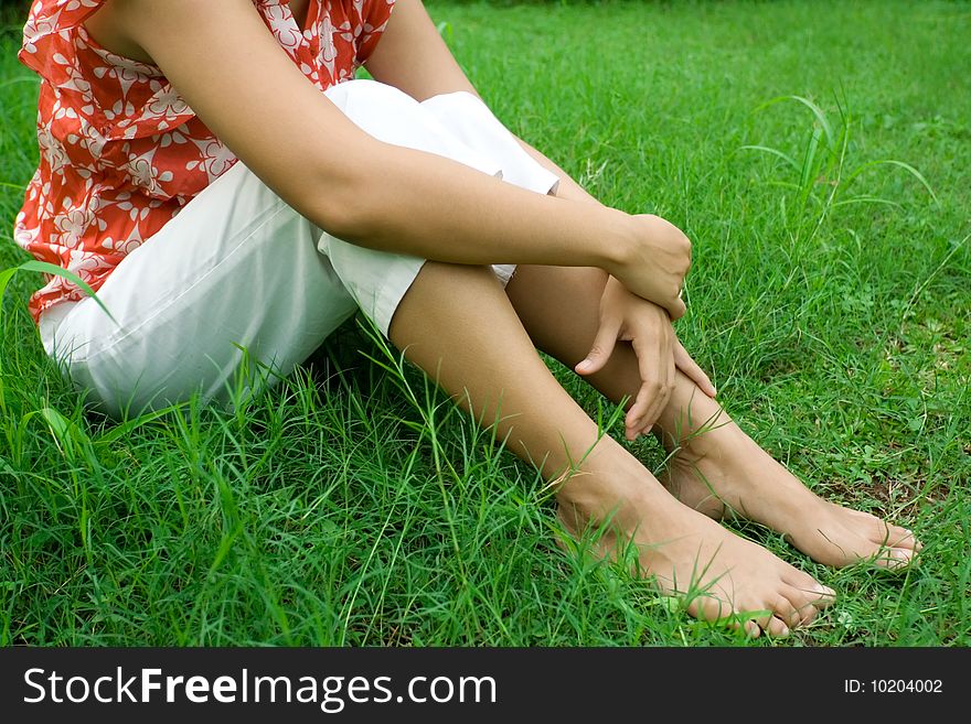 Conceptual portrait of a young asian woman sitting in the green grass, relaxing and enjoying a beautiful day outdoor. Conceptual portrait of a young asian woman sitting in the green grass, relaxing and enjoying a beautiful day outdoor