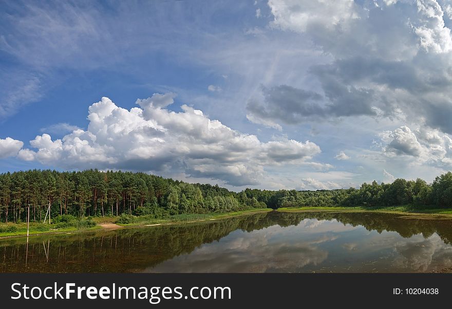 Landscape with lake on which coast a pine forest.