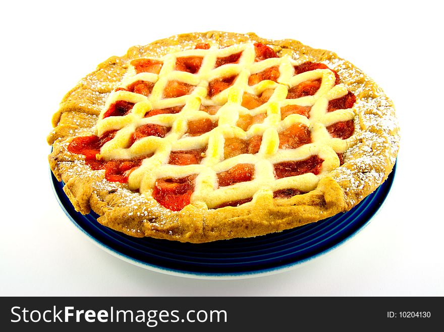 Whole apple and strawberry pie on a blue plate on a white background