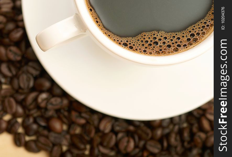 Cup of coffee on coffee beans background