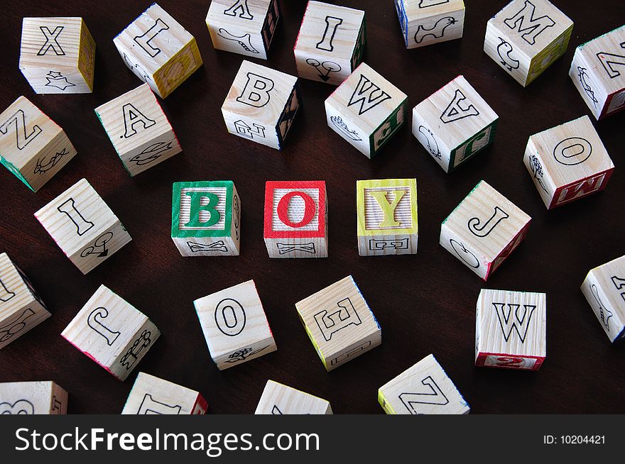 The word boy spelled out in wooden letter blocks. The word boy spelled out in wooden letter blocks