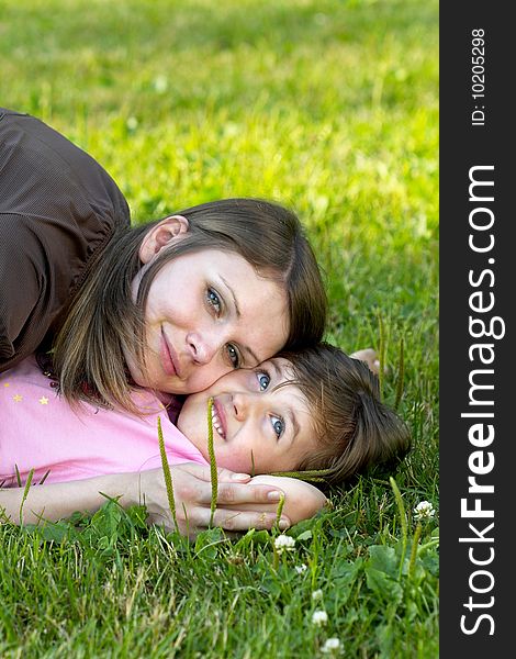Mother and daughter lying on the grass in the park