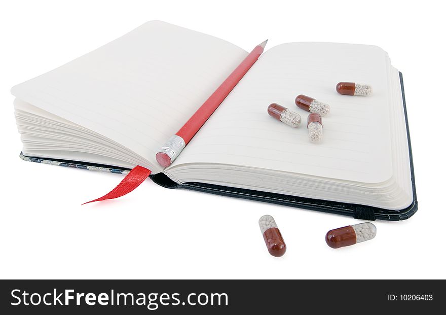 Open diary with pencil and pills isolated. Open diary with pencil and pills isolated