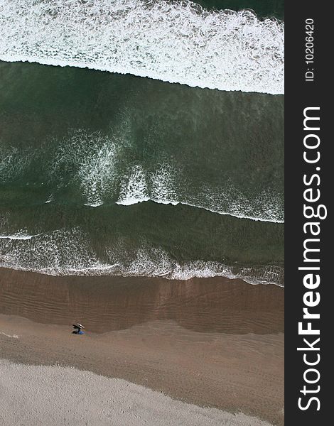 Aerial view of two surfers walking along the beach Las Machas in Arica Chile