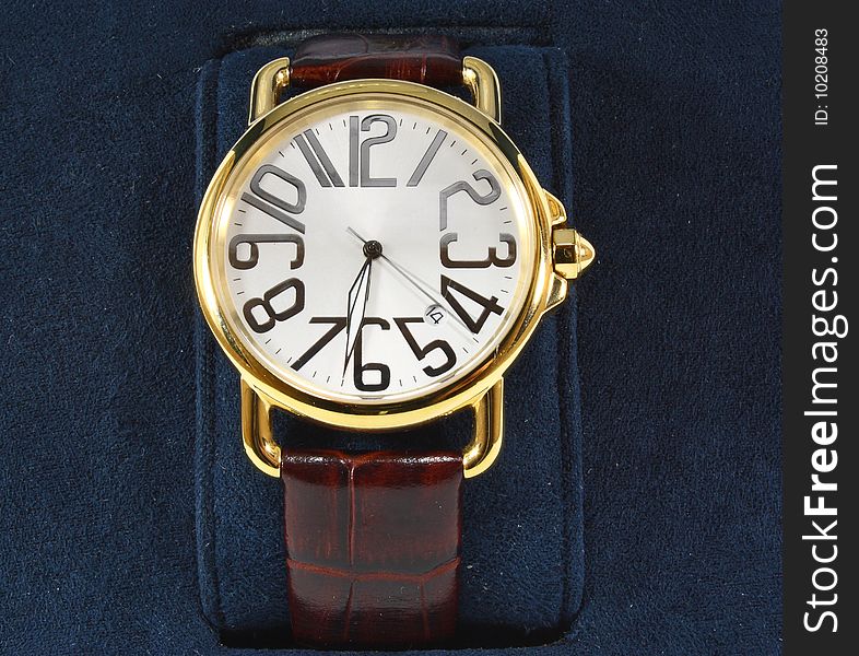 Golden watch on blue background