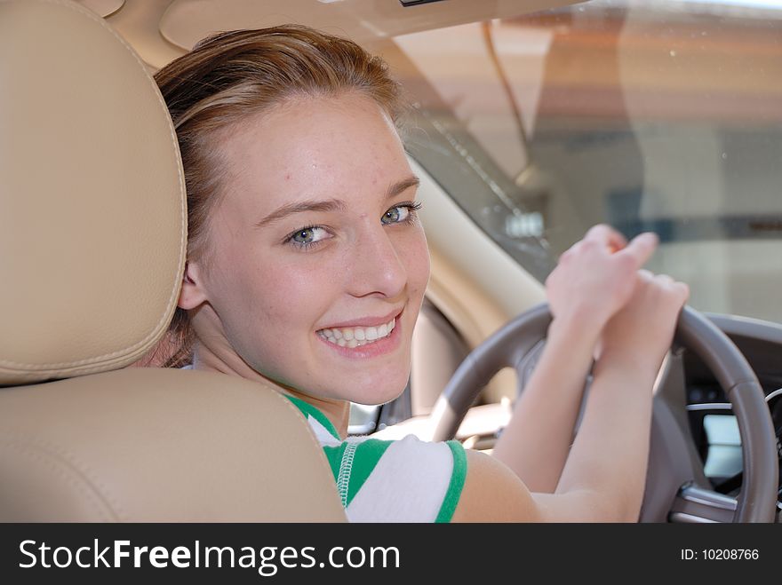 Teen behind steering wheel of a car