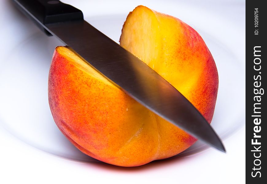 Ripe peach knifed isolated white