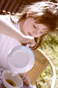The Beautiful Little Girl Pours Hot Tea Royalty Free Stock Photography The Beautiful Little Girl Pours Hot Tea Royalty Free Stock Photography