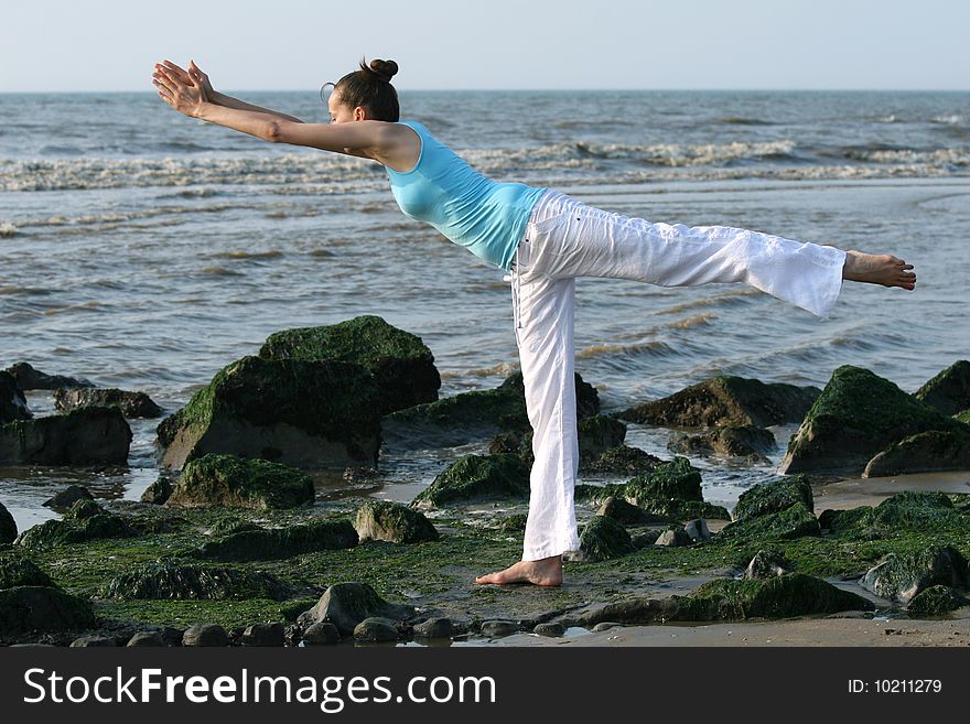 Woman doing yoga exercises at the beach. Woman doing yoga exercises at the beach