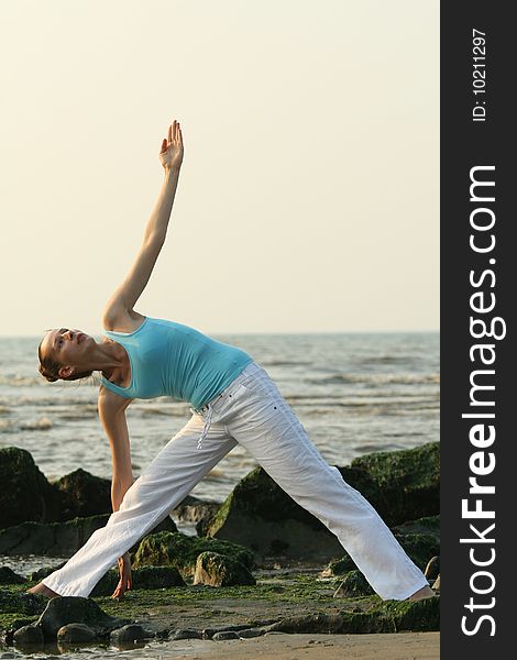 Woman doing yoga workout at the beach. Woman doing yoga workout at the beach