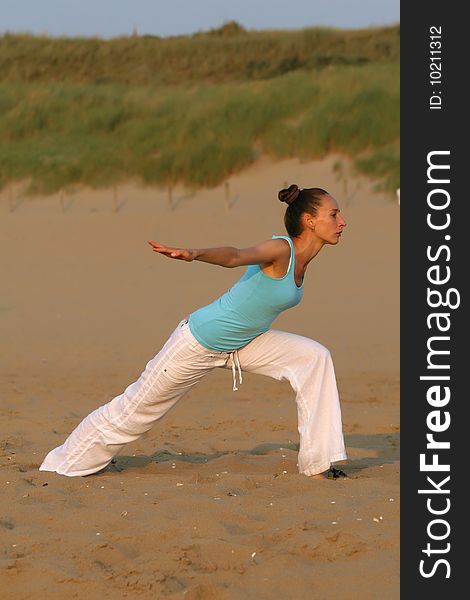 Woman doing yoga workout at the beach. Woman doing yoga workout at the beach