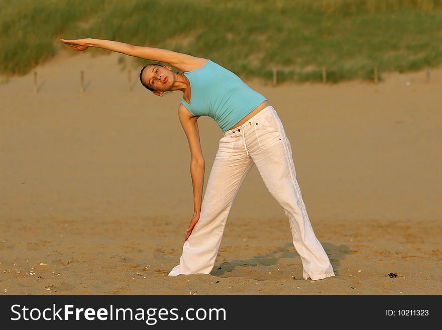 Woman doing yoga workout at the beach. Woman doing yoga workout at the beach