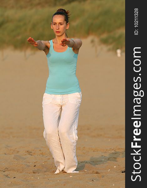 Woman doing breathing exercises at the beach