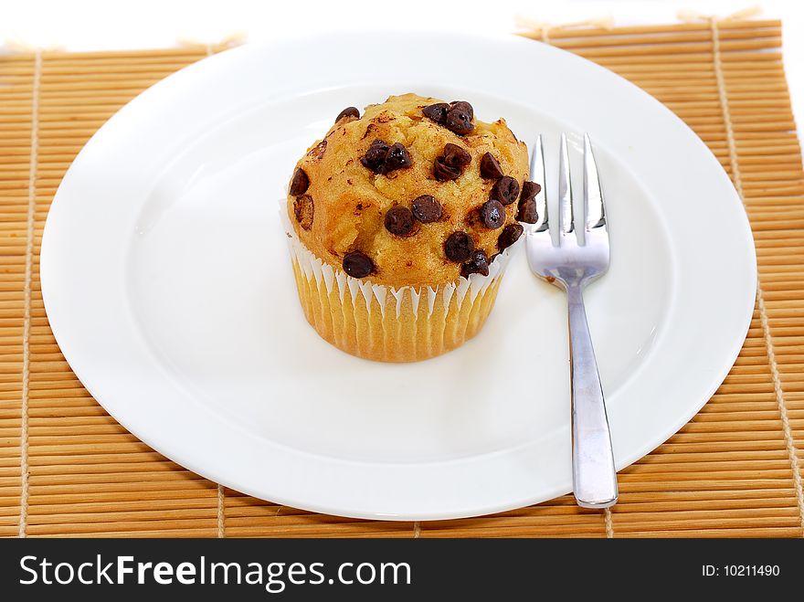 Isolated chocolate chips vanilla baked muffin. Isolated chocolate chips vanilla baked muffin