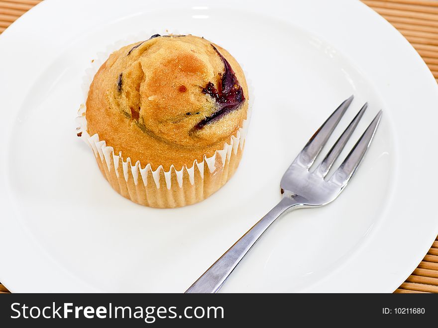 Isolated Blueberry favor baked muffin on plate. Isolated Blueberry favor baked muffin on plate