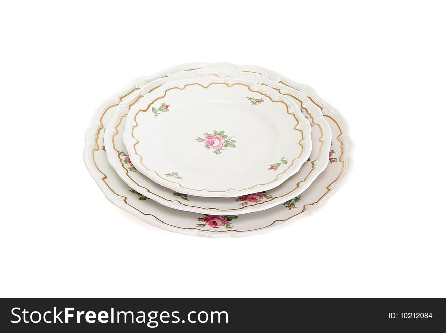 Stack of three white dinner plates and saucers with flowers and wavy rim isolated. Stack of three white dinner plates and saucers with flowers and wavy rim isolated
