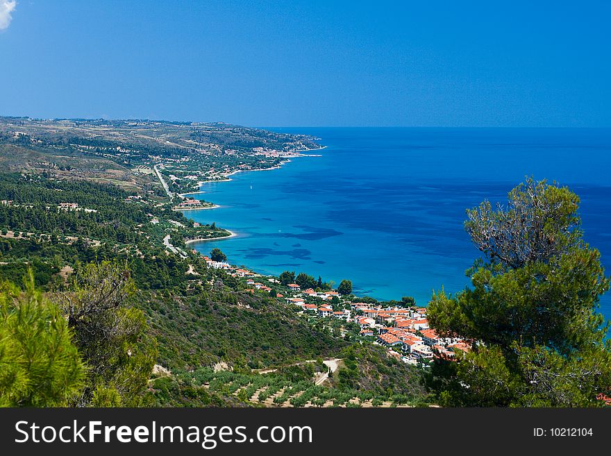 Marine landscape. Greece, Kassandra, Chalkidiki. Blue sae and sky, small towns with red roofs.