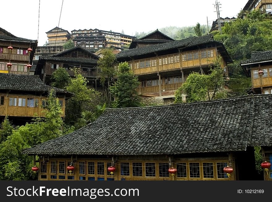 Chinese village Longshan in Guangxi province, near Guilin city. Wooden houses in high mountains, surrounded by terraced rice fields. Chinese village Longshan in Guangxi province, near Guilin city. Wooden houses in high mountains, surrounded by terraced rice fields.