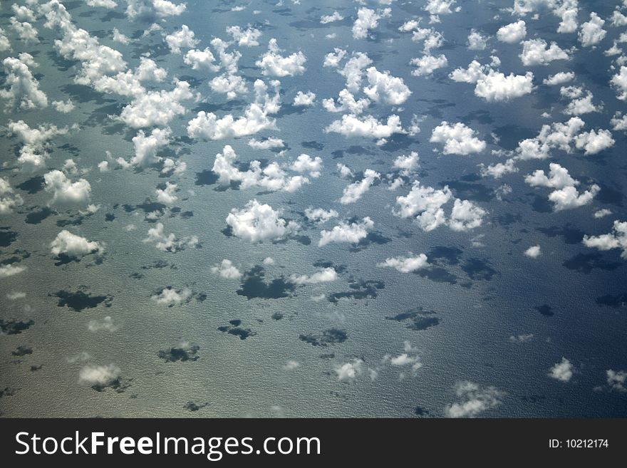 A group of single, isolated clouds on the water in this aerial viewfrom the Atlantic ocean.