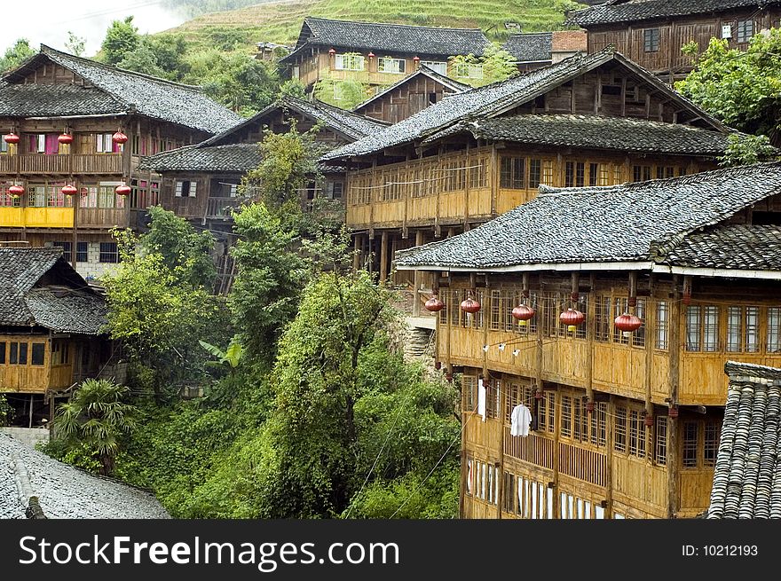 Chinese village Longshan in Guangxi province, near Guilin city. Wooden houses in high mountains, surrounded by terraced rice fields. Chinese village Longshan in Guangxi province, near Guilin city. Wooden houses in high mountains, surrounded by terraced rice fields.