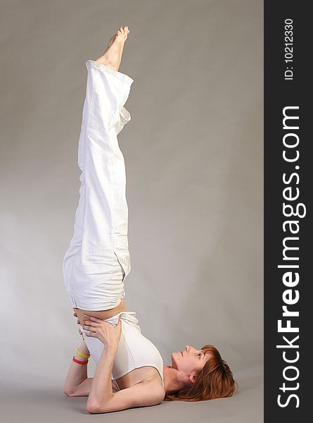 Girl practicing yoga on grey background