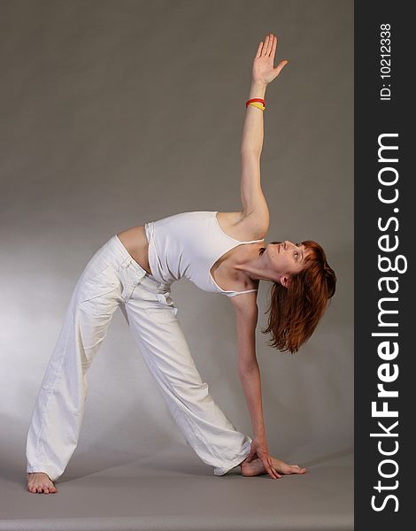 Girl practicing yoga on grey background