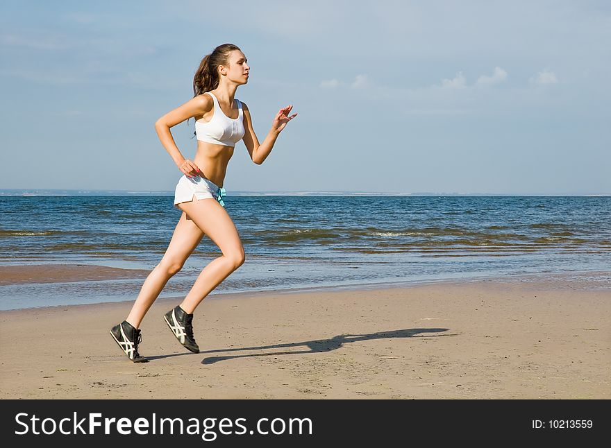 Young woman running alone on the beach