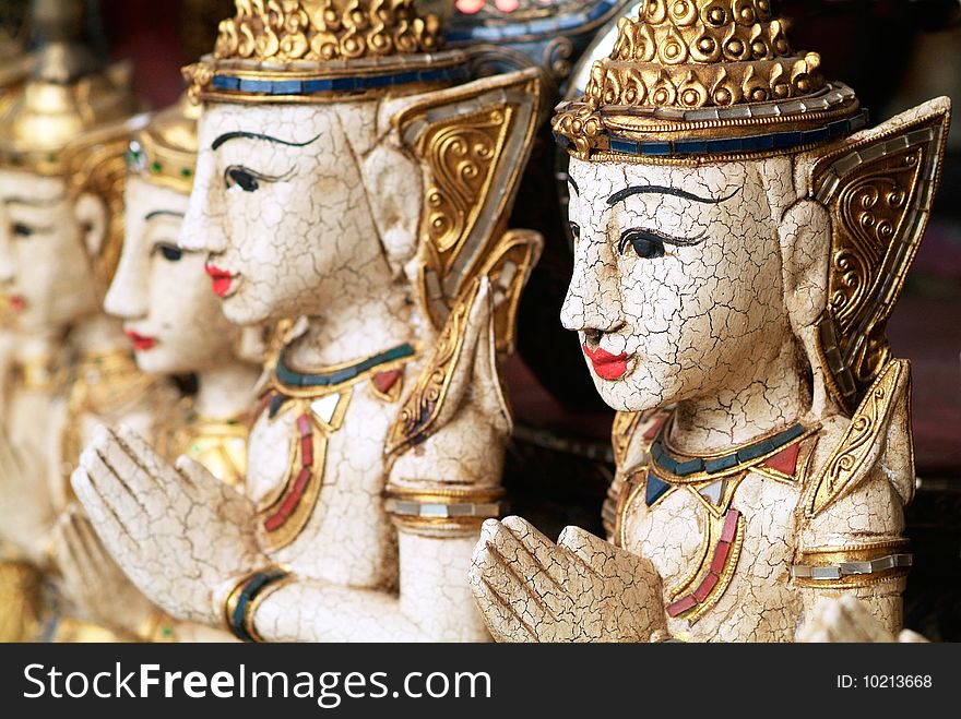 Religious images at Buddhist temple in northern Thailand. Shallow depth of field with the first image in focus.