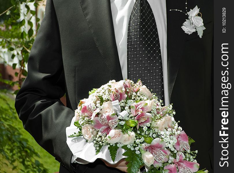 Man in black coat with bridal bouquet. Man in black coat with bridal bouquet