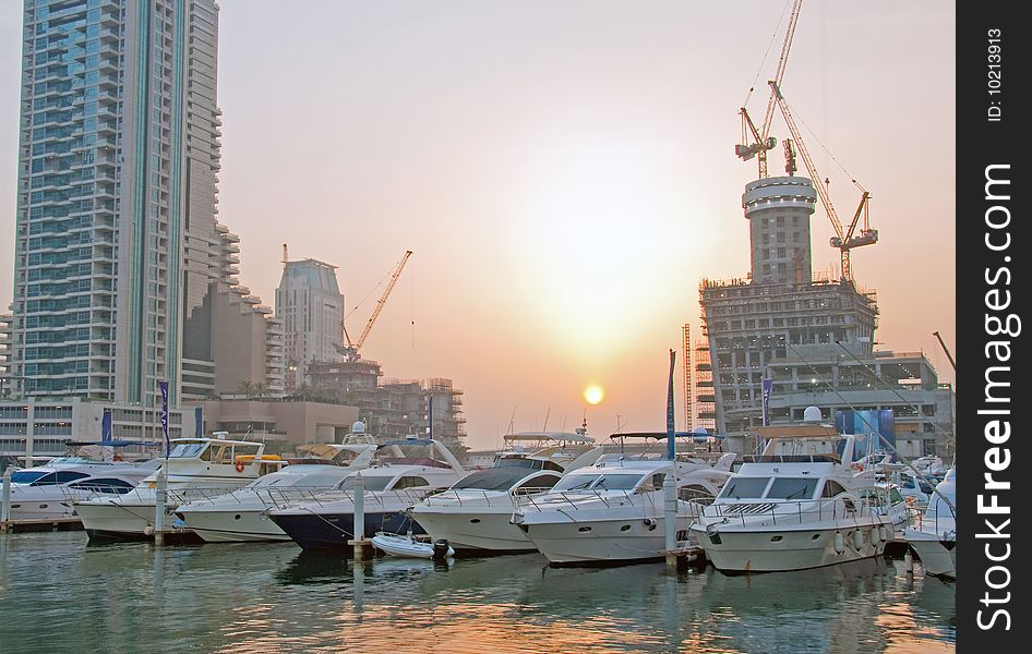 Luxury Boats berthing in Dubai Marina with buildings being built in the background. Luxury Boats berthing in Dubai Marina with buildings being built in the background