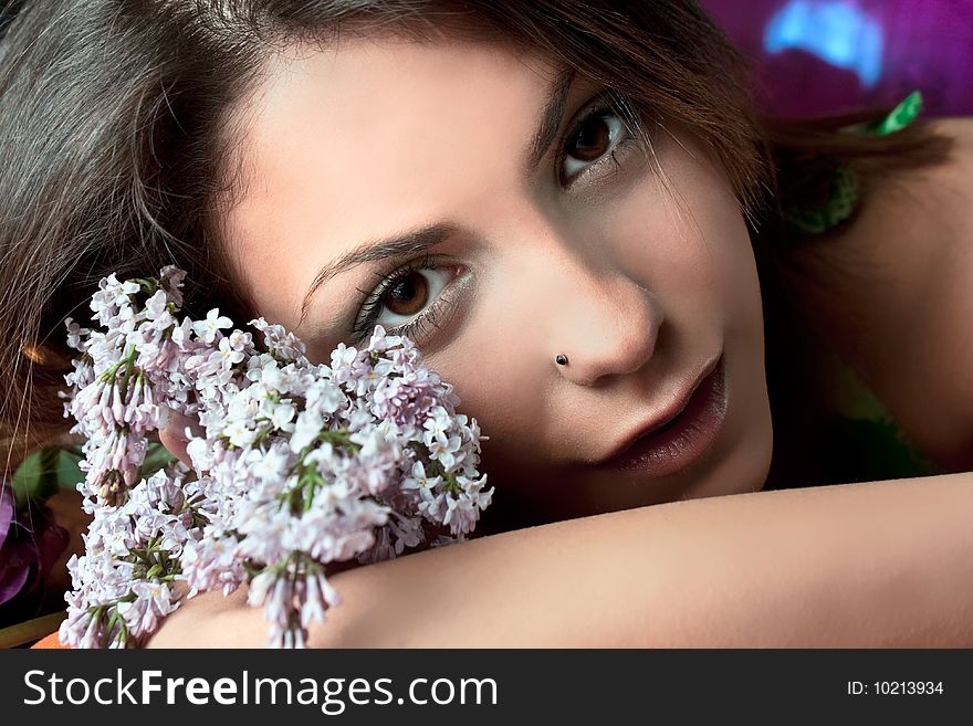 Pretty woman with flowers  in summer time, studio shot