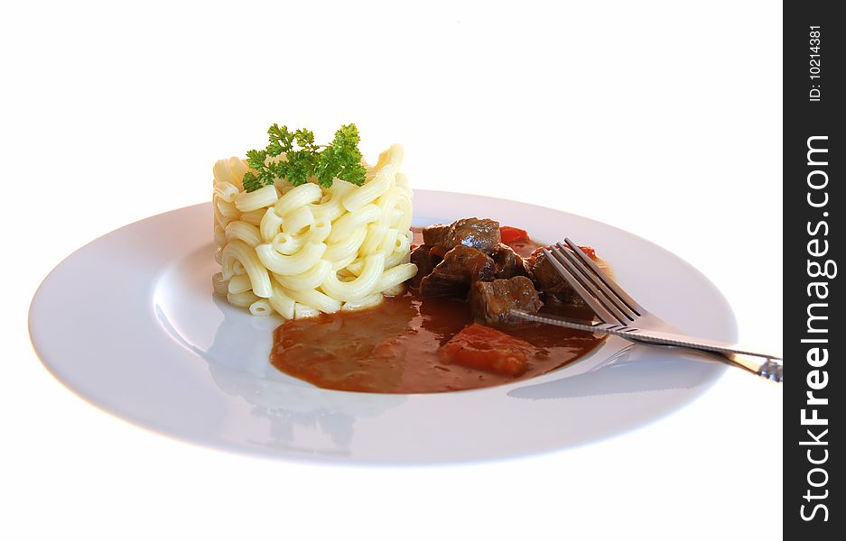 Goulash with noodles on a white plate