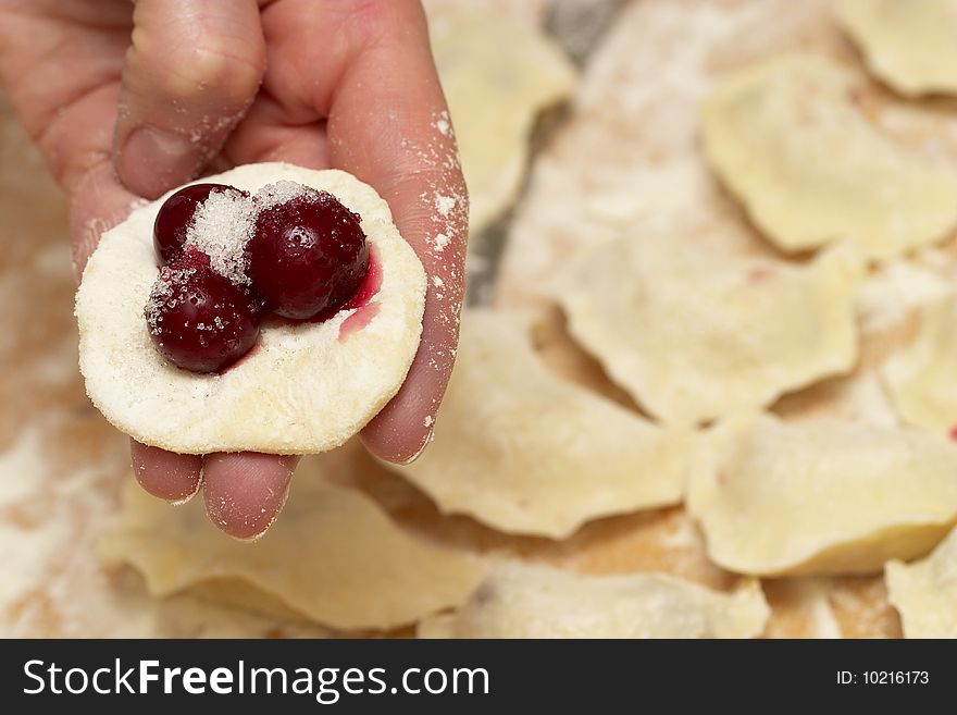 Preparing (cooking) traditional Ukrainian vareniks with cherry