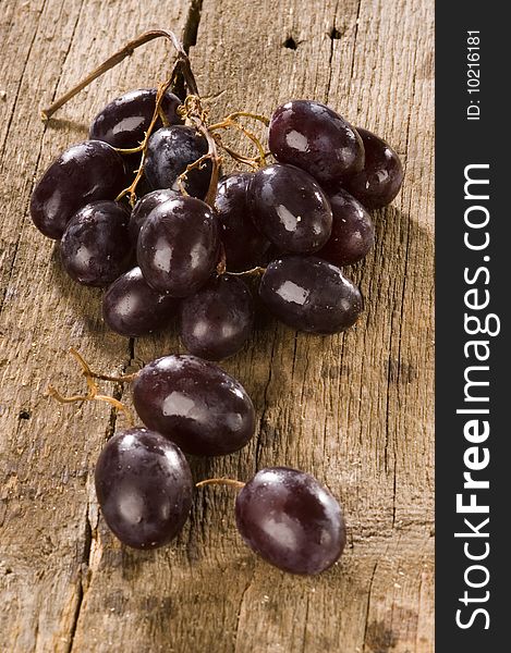 Red grapes on an old wooden table