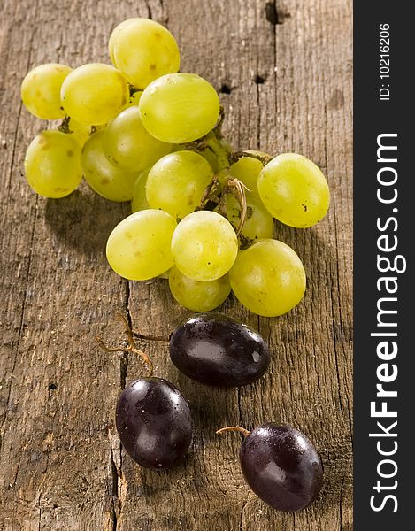 Red and green grapes on an old wooden trable