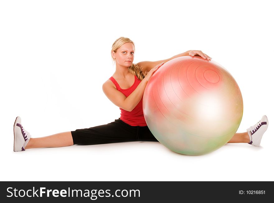 Blond woman exercising with a pilates ball over white background