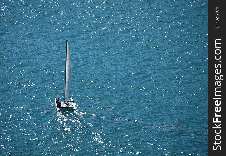 A shot of a beautiful boat alone in the blue of the water. A shot of a beautiful boat alone in the blue of the water