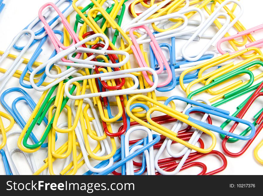 Coloured paperclips background isolated on white