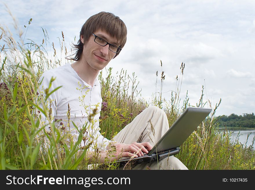 The man with laptop on green grass