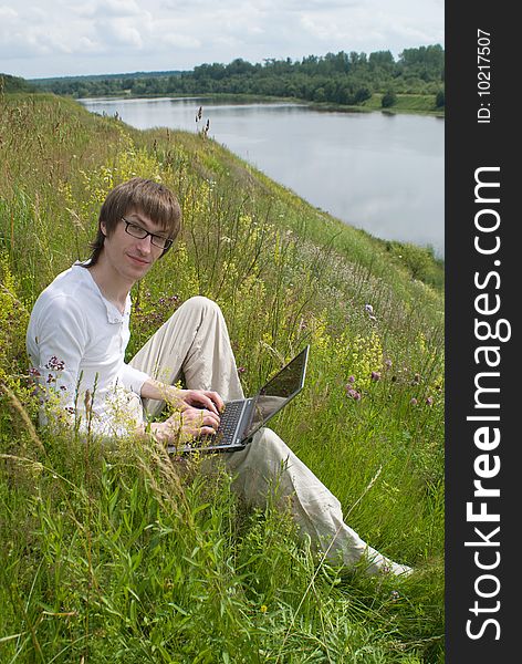 The man with laptop on green grass