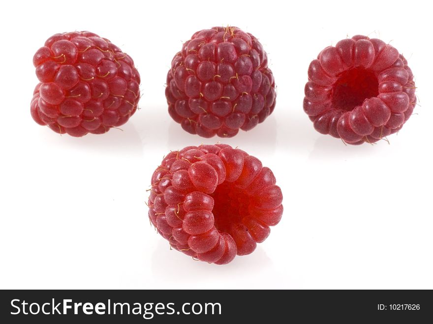 Four raspberries on white, one in the front and four in the back. Four raspberries on white, one in the front and four in the back.