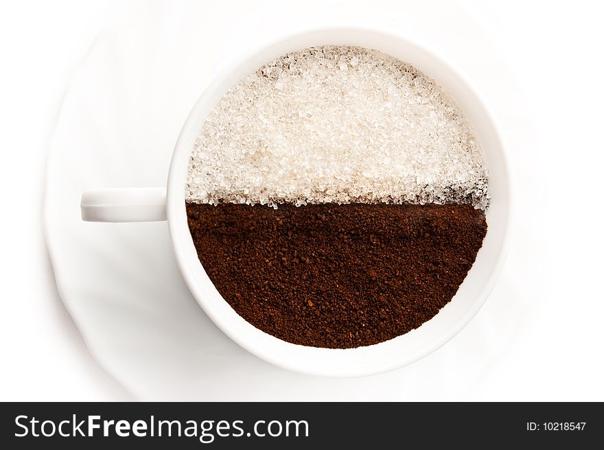 Cup full of ground coffee and white sugar is isolated over a white background. Cup full of ground coffee and white sugar is isolated over a white background