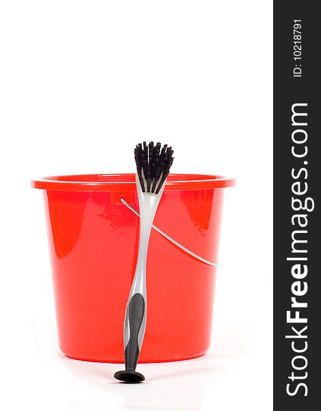 Red bucket with gray dishwashing brush isolated on white