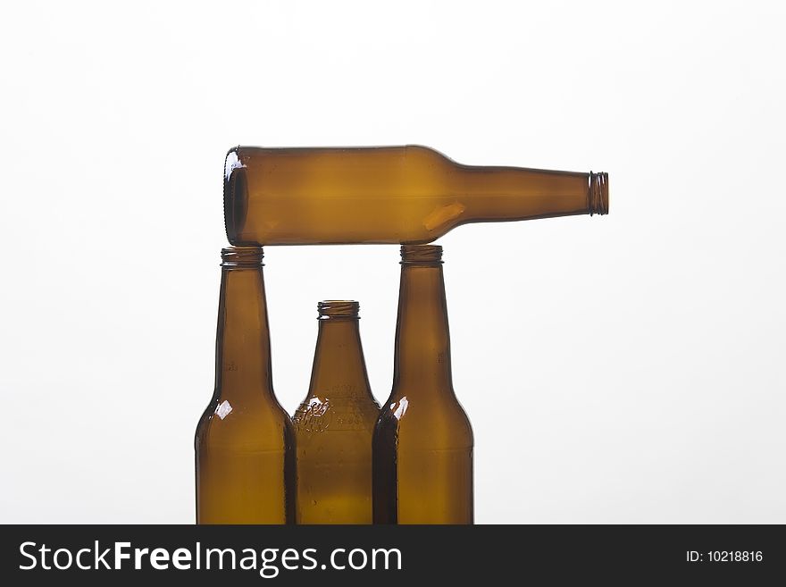 Close up of empty brown glass bottle balanced on two other bottles. Close up of empty brown glass bottle balanced on two other bottles.