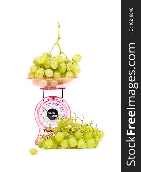 Kitchen Scales filled with green grapes isolated over white