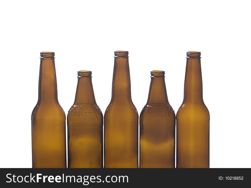 Five brown glass bottles against a white background. Five brown glass bottles against a white background.