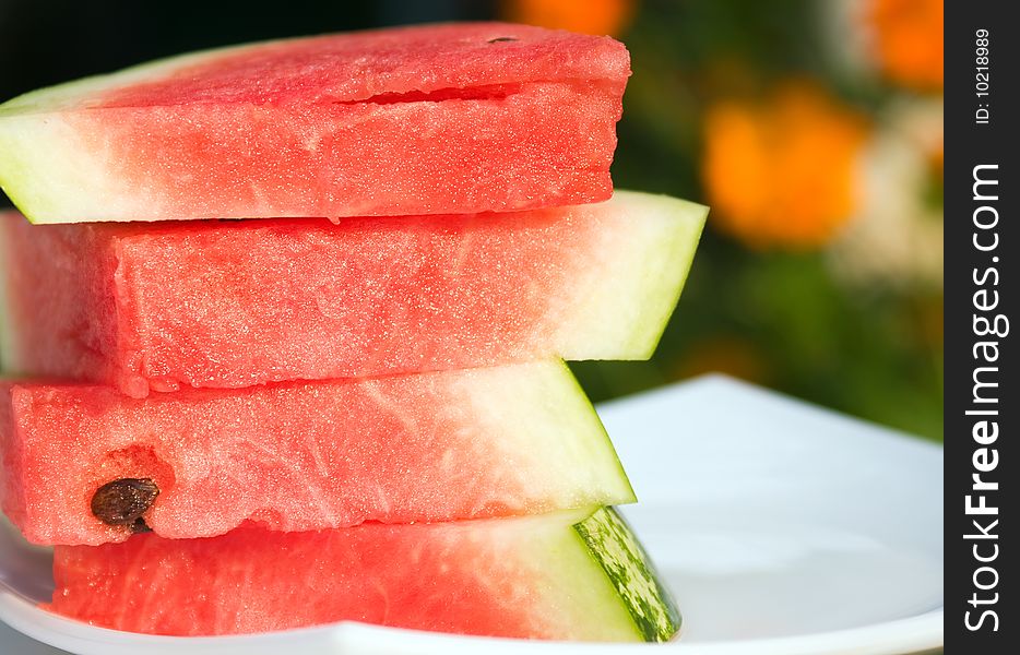 Fresh slices of watermelon on a white plate