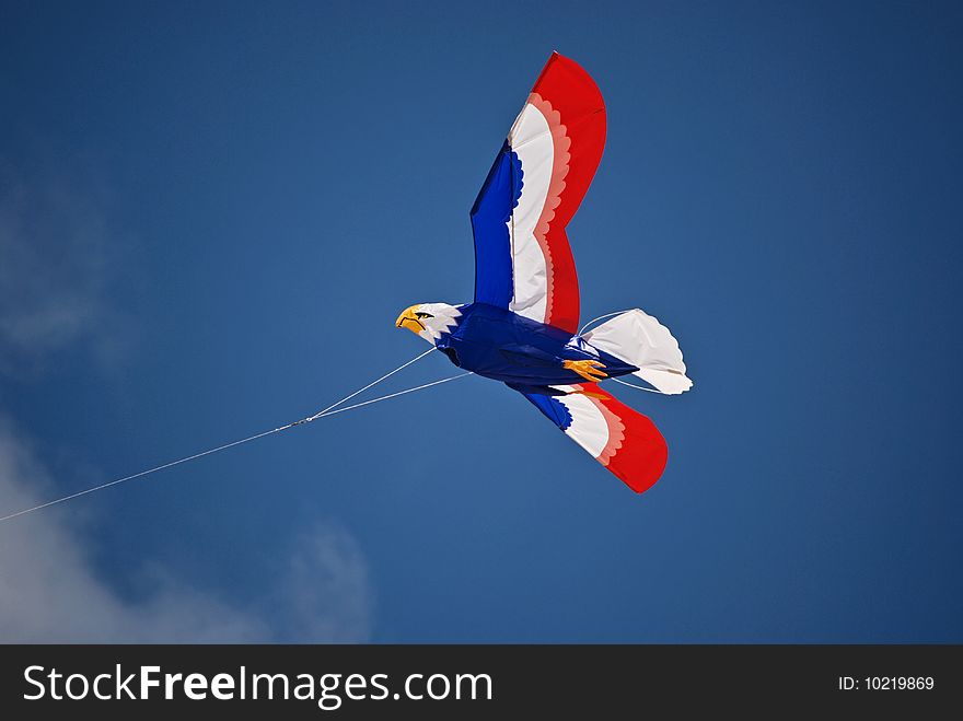 Patriotic eagle kite soaring in the summer sky.