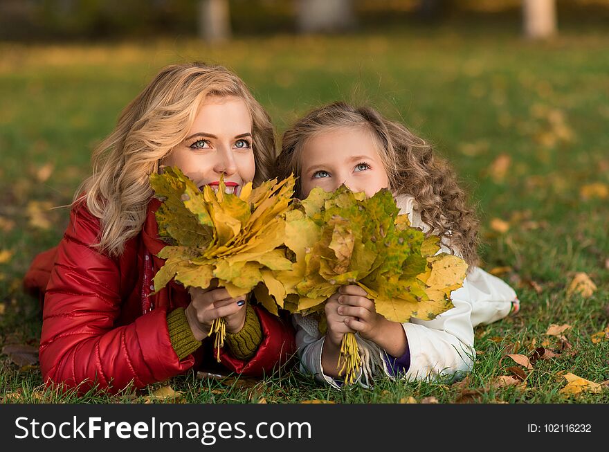 Beautiful Mother And Daughter In Colorful Autumn Outdoors